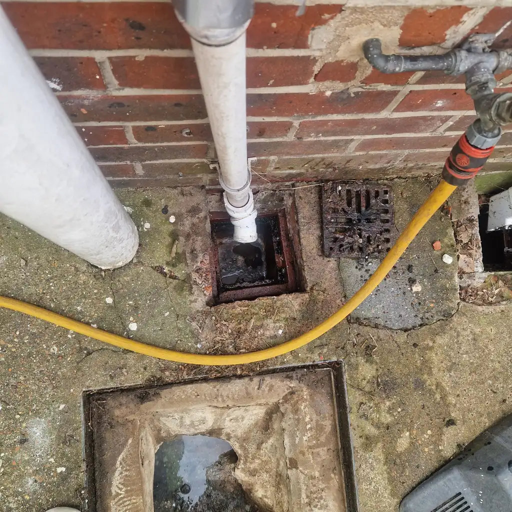 Blocked gully being cleaned before drain relining works begin