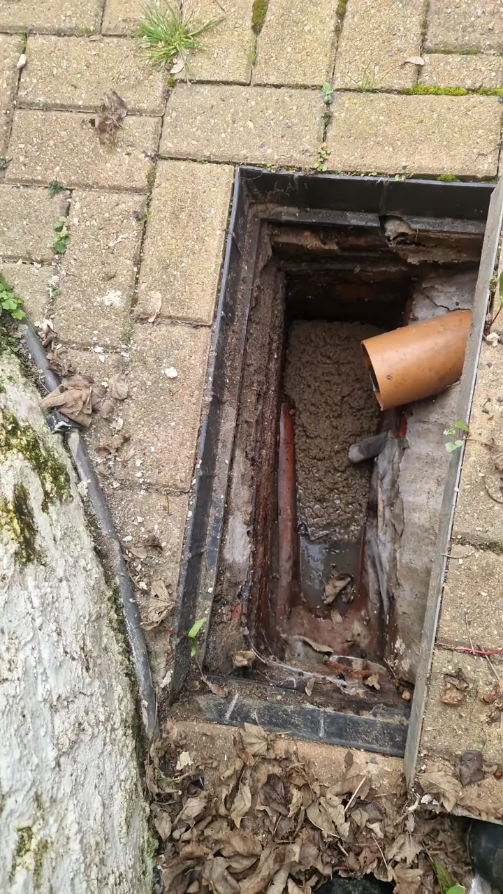 Inspection chamber below block paving holding waste and broken pipe
