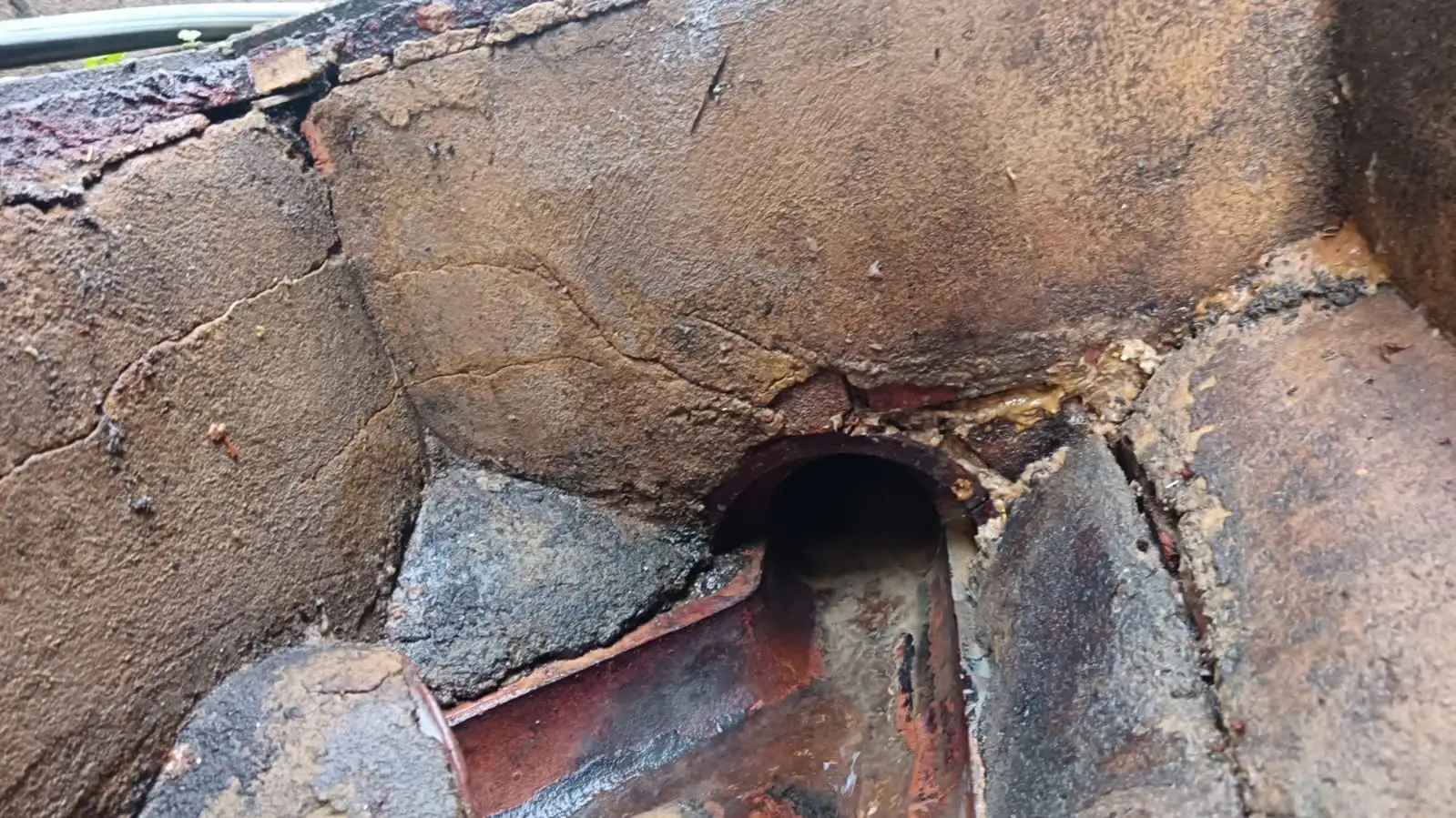 Brick drain chamber outlet showing wider drainage pipework