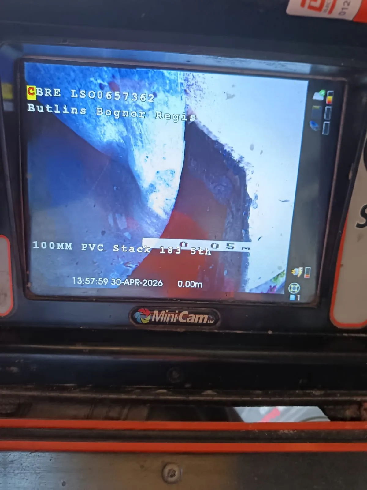 CCTV drain survey camera being fed into an outside drain to locate a blockage