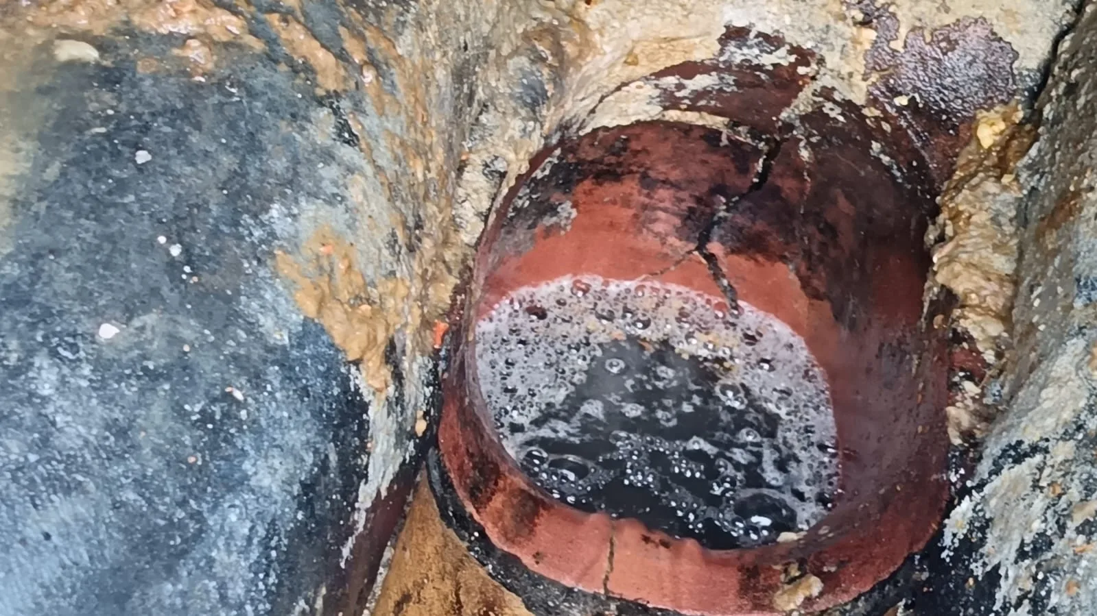 Cracked clay drain pipe showing damage risk during drain descaling cost work