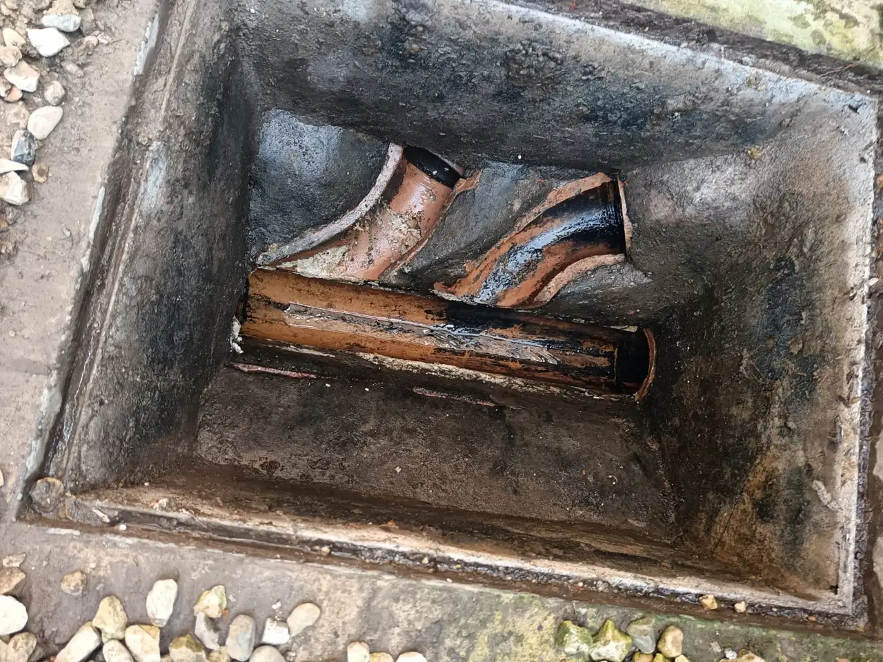Damaged drain channel showing wear consistent with untreated scale buildup
