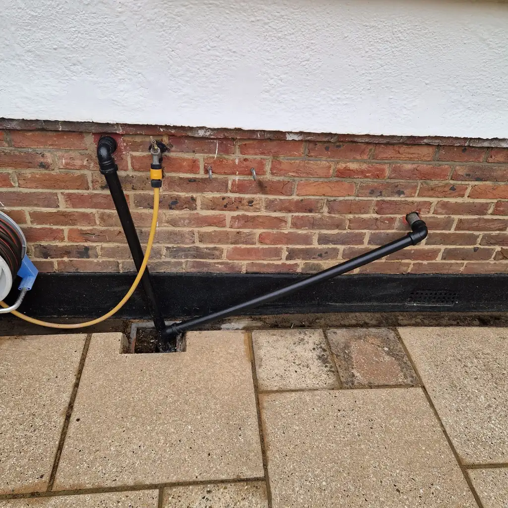 External waste pipe gully being cleared as part of jet washing drains cost job