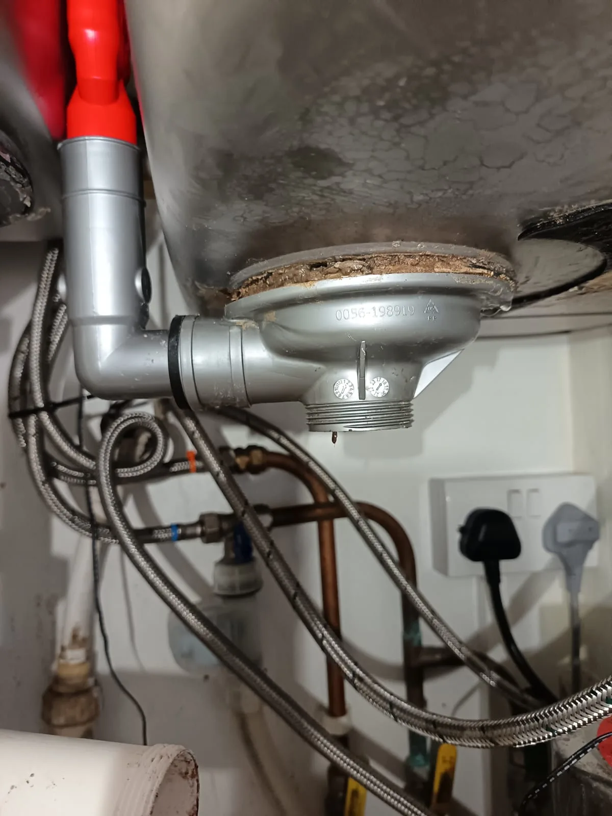 Engineer dismantling kitchen sink waste to trace a drain run before a house buying drain survey