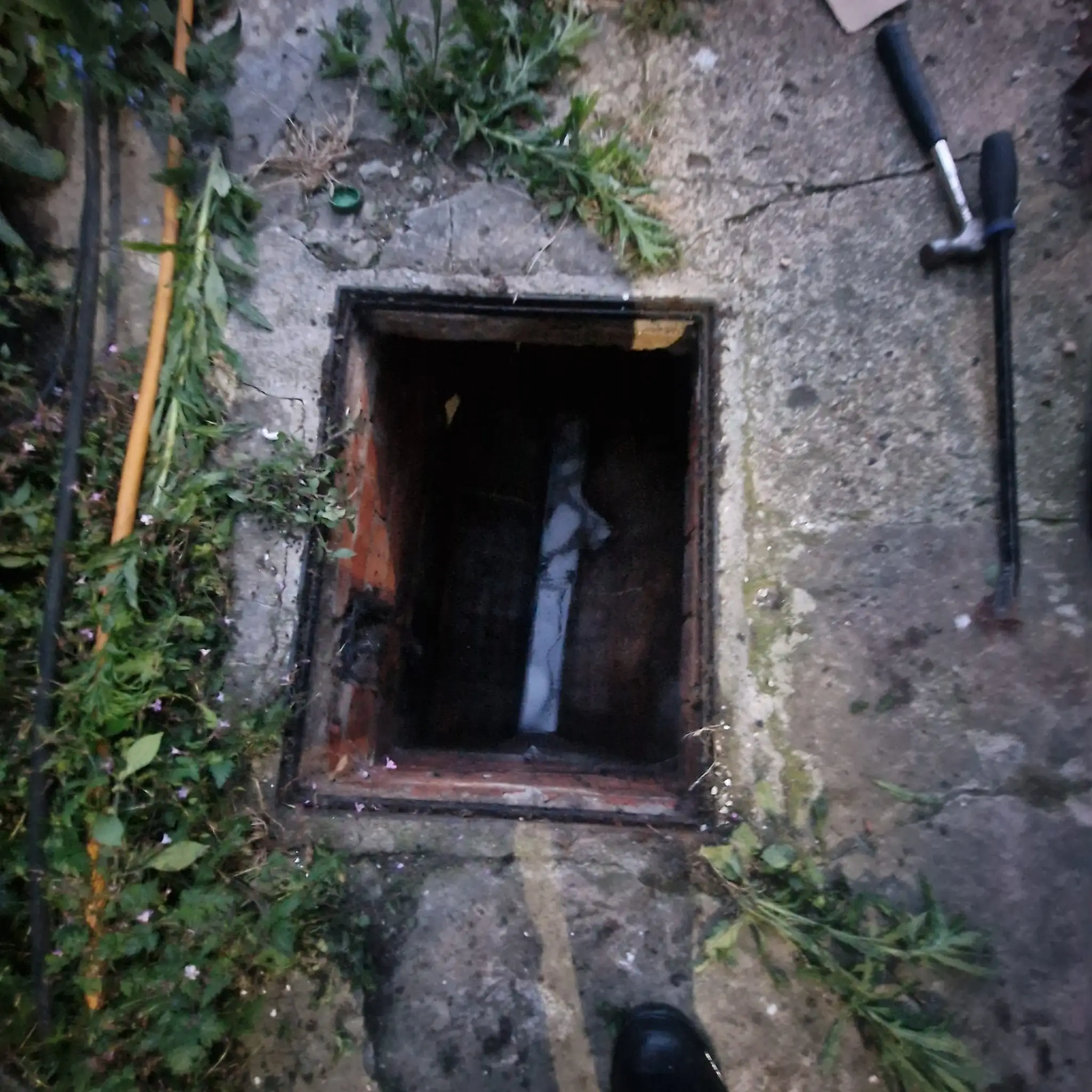 Manhole cover lifted for drain access before excavation work begins