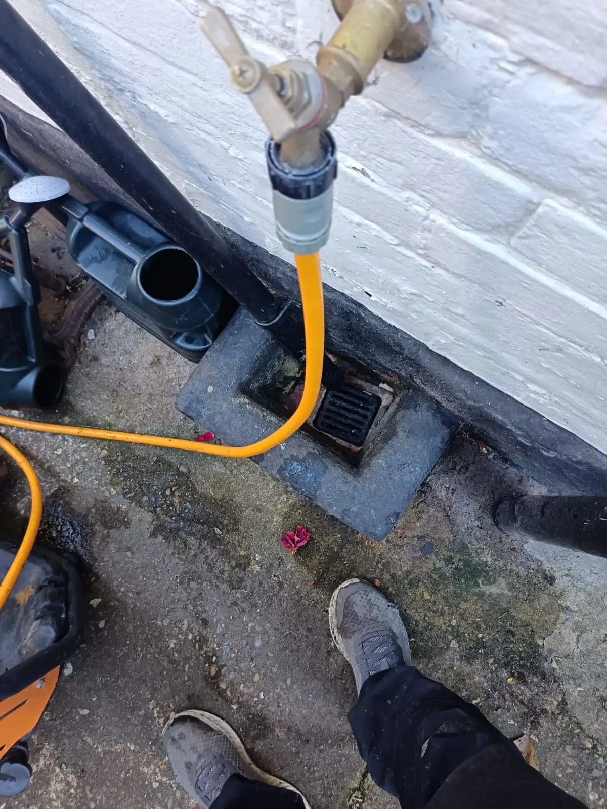 Engineer jetting blocked drain in Brentford using outside tap supply