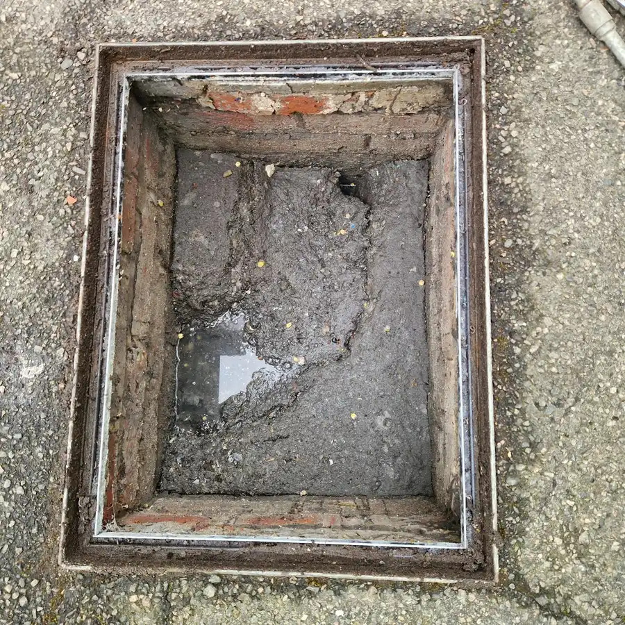 Silted inspection chamber showing signs consistent with an upstream collapsed drain