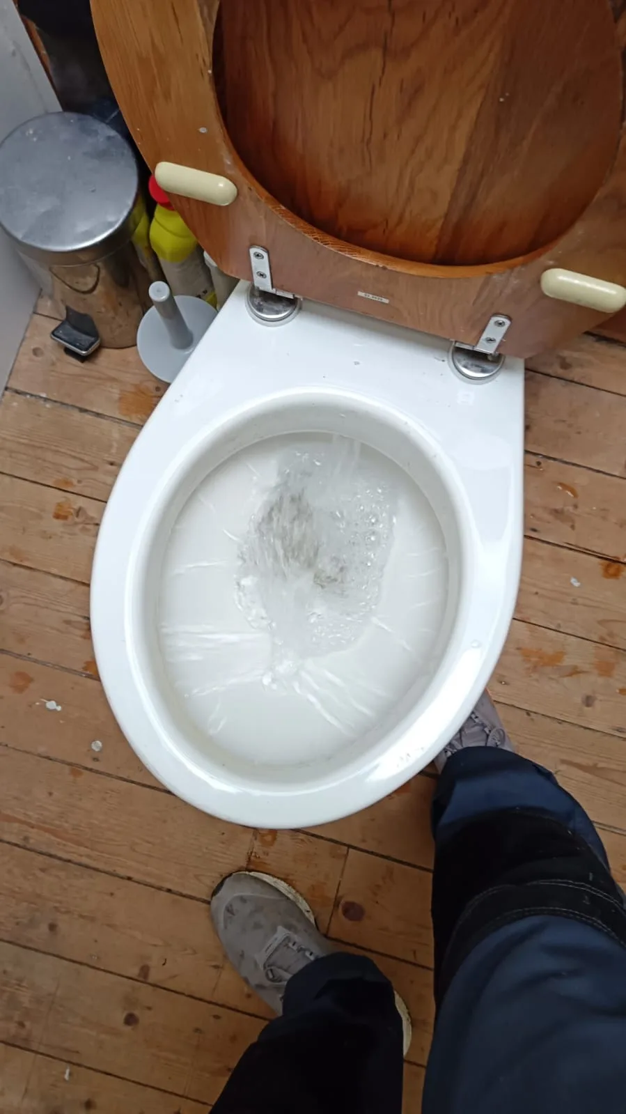 Plumber testing toilet flush after clearing a blockage - cost to unblock a toilet